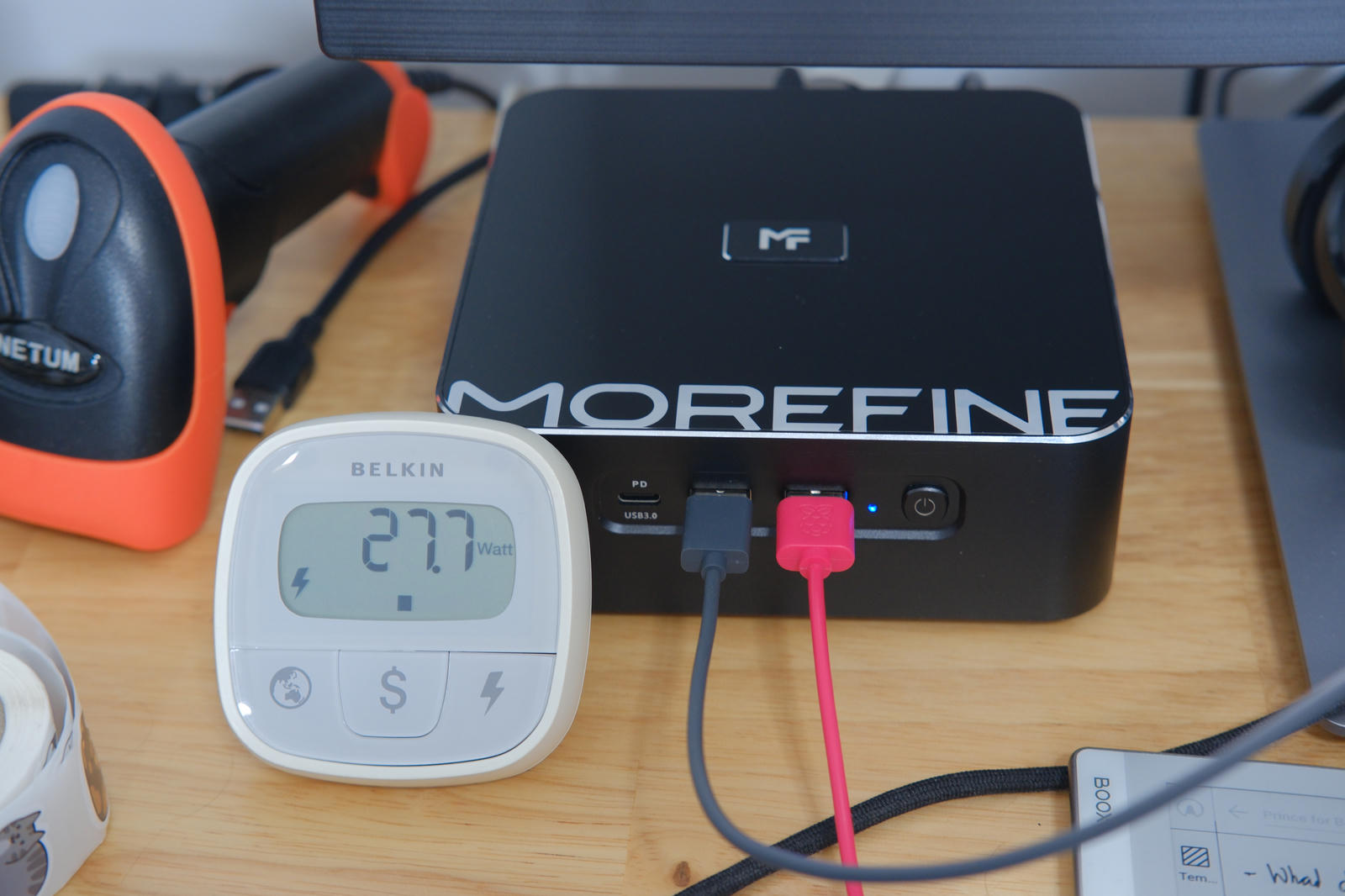 Photo of a watt-meter in front of the M700S showing 27.7W of power.